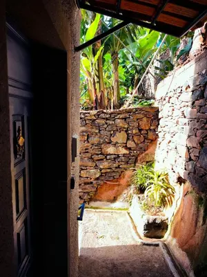 an entrance to a house with a stone wall at Cascata da Giesta House in Câmara de Lobos
