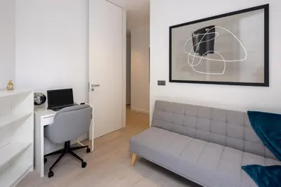 a living room with a couch and a desk with a laptop at A&M House III in Arco da Calheta