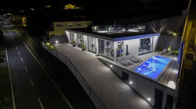 a house with a swimming pool at night at A&M House III in Arco da Calheta