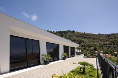 a house with a balcony with plants on it at A&M House III in Arco da Calheta
