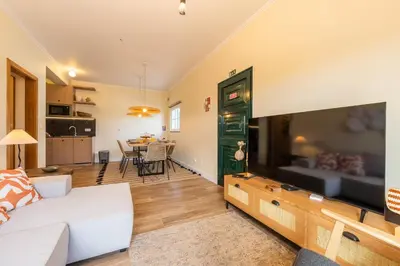 a living room with a white couch and a tv at Beach Retreat - By Wehost in Porto Santo