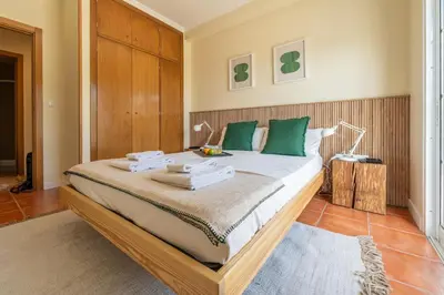 a bedroom with a large bed with green pillows at Beach Retreat - By Wehost in Porto Santo