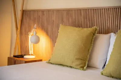 a bed with a pillow and a lamp on a table at Beach Retreat - By Wehost in Porto Santo