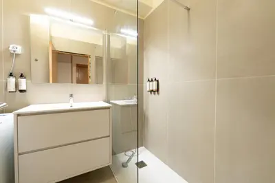 a white bathroom with a sink and a shower at Beach Retreat - By Wehost in Porto Santo