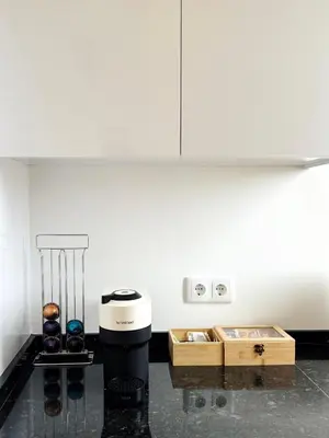 a white kitchen with a coffee maker and wooden crates at S A L - Village Flats in Caniçal