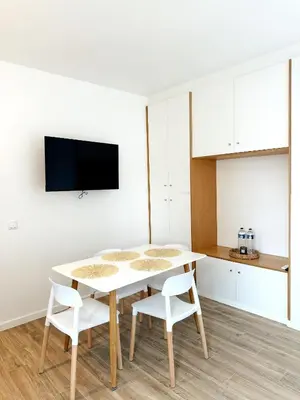 a white kitchen with a table and two white chairs at S A L - Village Flats in Caniçal