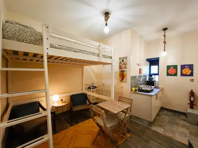 a room with bunk beds and a table and a desk at Studio Cascata da Giesta in Câmara de Lobos