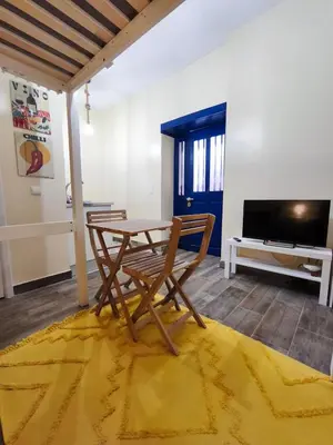 a table and chairs in a room with a television at Studio Cascata da Giesta in Câmara de Lobos