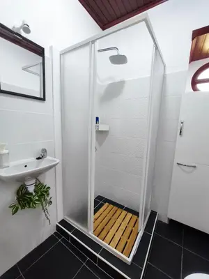 a shower with a glass door in a bathroom at Studio Cascata da Giesta in Câmara de Lobos