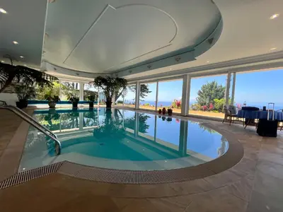 a swimming pool in a building with a view of the ocean at PRIVATE OCEANFRONT DELUXE VILLA PICO 360 VIEWs in Funchal