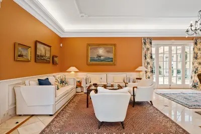 a living room with white furniture and orange walls at PRIVATE OCEANFRONT DELUXE VILLA PICO 360 VIEWs in Funchal