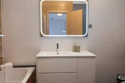 a bathroom with a sink and a mirror and a tub at Titou Apartment Sea View in Santa Cruz