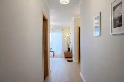 a hallway with a white wall and a room with a table at Titou Apartment Sea View in Santa Cruz
