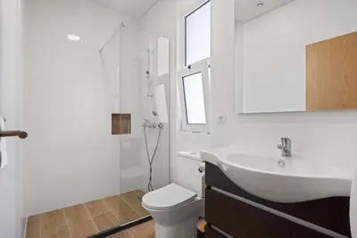 a white bathroom with a sink and a toilet at Villa Por do Sol in Ponta do Sol