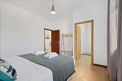 a white bedroom with a bed and a mirror at Villa Por do Sol in Ponta do Sol