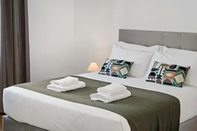 a bedroom with a large bed with towels on it at Villa Por do Sol in Ponta do Sol
