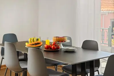 a dining room table with a tray of fruit on it at Villa Por do Sol in Ponta do Sol