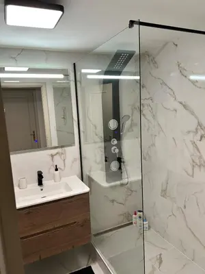 a bathroom with a sink and a glass shower at Jardim do Caniço in Caniço