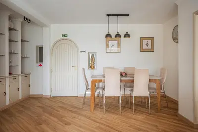 a kitchen and dining room with a table and chairs at Jardim do Caniço in Caniço
