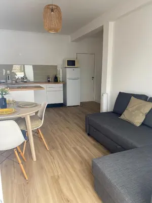 a living room with a couch and a table and a kitchen at Sea La Vie Apartment Porto Santo in Porto Santo