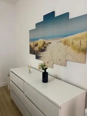a room with a dresser and a painting of a beach at Sea La Vie Apartment Porto Santo in Porto Santo