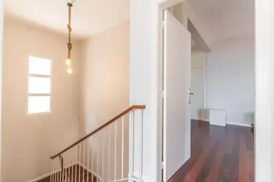 a staircase in a home with white walls and wood floors at Casa dos Namora by Atlantic Holiday in Câmara de Lobos