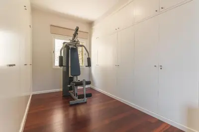 a gym with a treadmill in a room with white walls at Casa dos Namora by Atlantic Holiday in Câmara de Lobos