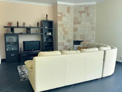 a living room with a white couch and a tv at Vista Ventura in Ponta Delgada