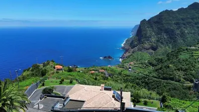 a house on a hill next to the ocean at Vista Ventura in Ponta Delgada