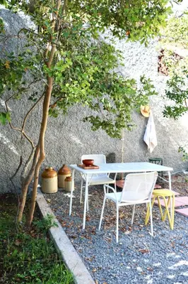 a table and chairs sitting next to a tree at Araça Studio - Atlantic Mountain Living in São Vicente