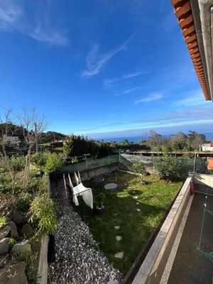 a view of a garden with two white chairs at Casa Costa in Santa Maria Madalena