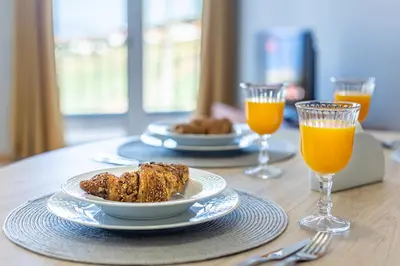 a table with two plates of food and two glasses of orange juice at Estrela house II Calheta Madeira in Calheta