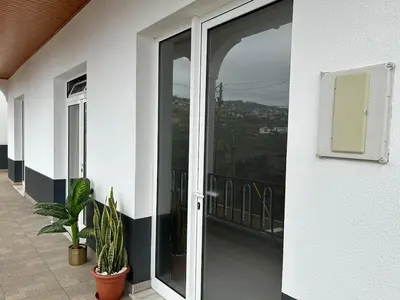 a sliding glass door on a building with plants at Estrela house II Calheta Madeira in Calheta