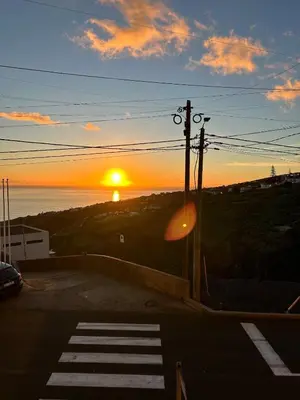 a sunset over a parking lot with the sun setting at Estrela house II Calheta Madeira in Calheta