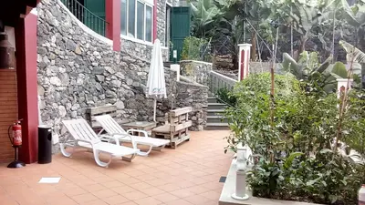 a patio with two chairs and an umbrella at Apart Monumental in Funchal
