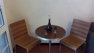 a table with two chairs and a bottle of wine at Apart Monumental in Funchal