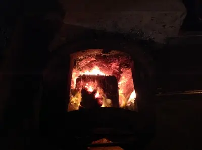 a fire in a brick oven in a dark room at Apart Monumental in Funchal
