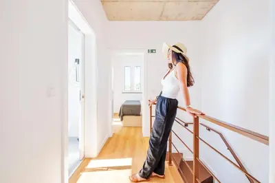 a woman in a hat is walking down the stairs at The Vinehill House in Câmara de Lobos