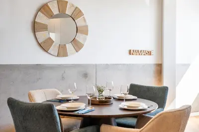 a dining room with a table with chairs and a mirror at The Vinehill House in Câmara de Lobos