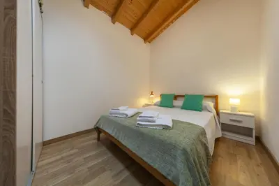 a bedroom with a bed with green pillows on it at A28 - Castela Street Townhouse in Espiche in Luz