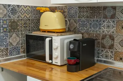 a microwave sitting on top of a kitchen counter at A28 - Castela Street Townhouse in Espiche in Luz