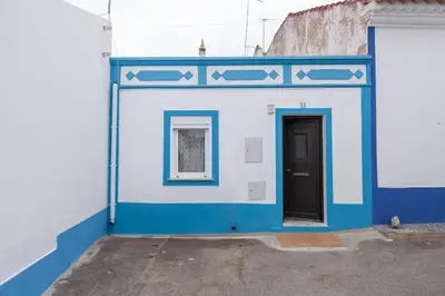a blue and white building with a door at A28 - Castela Street Townhouse in Espiche in Luz