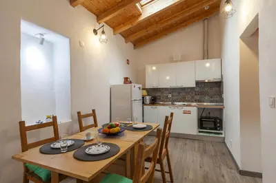 a kitchen and dining room with a table and chairs at A28 - Castela Street Townhouse in Espiche in Luz