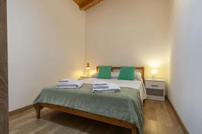a bedroom with a bed with green pillows on it at A28 - Castela Street Townhouse in Espiche in Luz