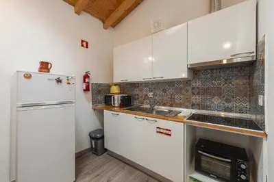 a kitchen with white cabinets and a refrigerator at A28 - Castela Street Townhouse in Espiche in Luz