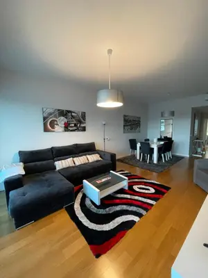 a living room with a black couch and a table at Sunny modern 2 bedroom apartment in Funchal