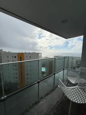 a balcony with two chairs and a view of a city at Sunny modern 2 bedroom apartment in Funchal