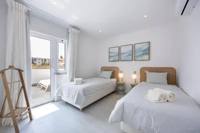 a bedroom with two beds and a balcony at Casa Gio in Luz