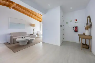 a white living room with a couch and a table at Casa Gio in Luz