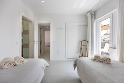 two beds in a white room with towels on them at Casa Gio in Luz